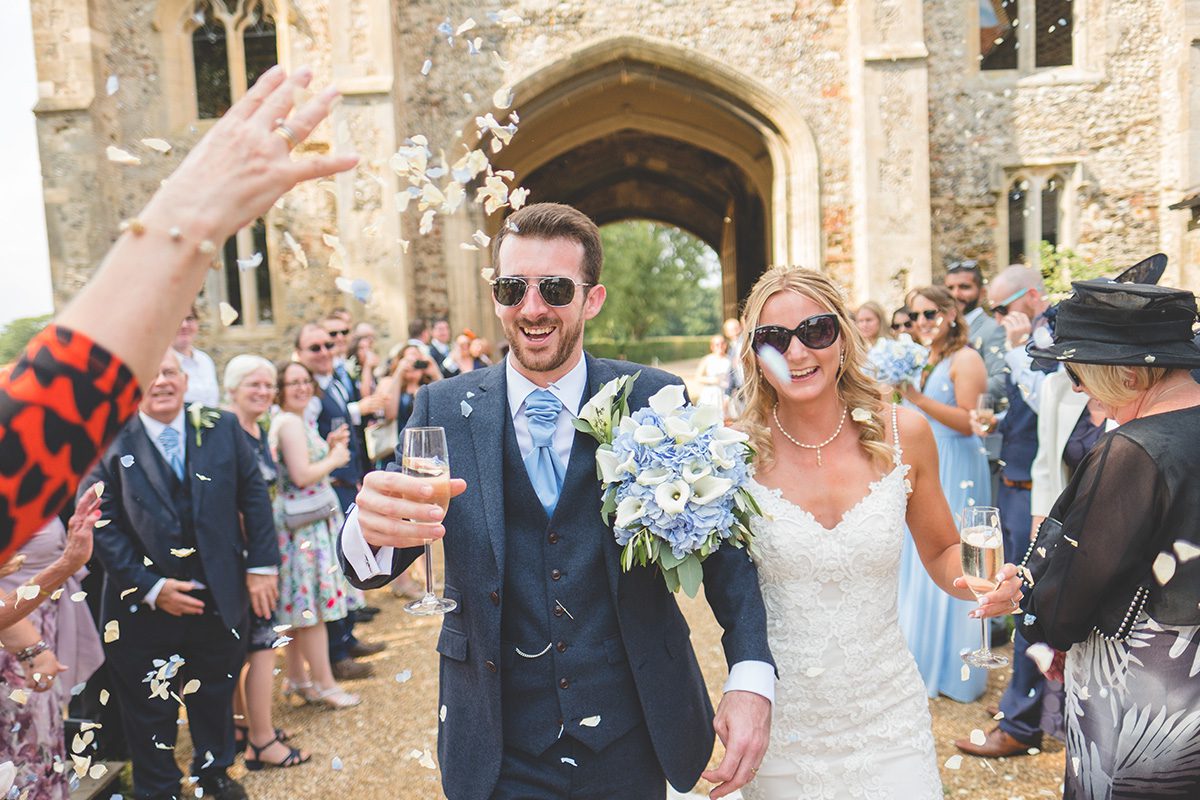 The happy newlyweds look cool in their sunglasses on their summer wedding day at Pentney Abbey in Norfolk