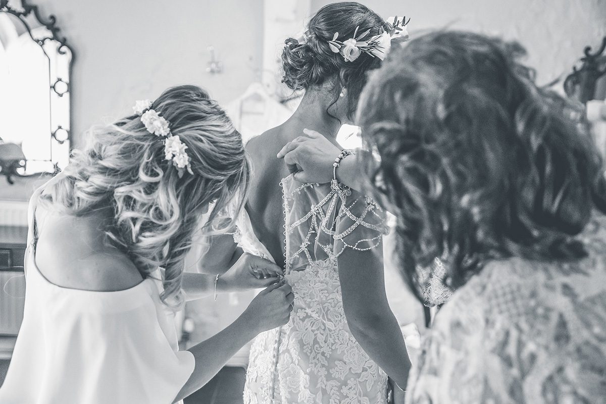 The bridesmaids make the last touches to the bride’s look as they prepare for the day ahead at Pentney Abbey